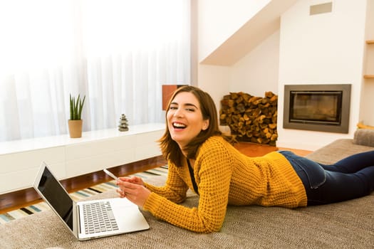 Gorgeous young woman at home texting and laughing
