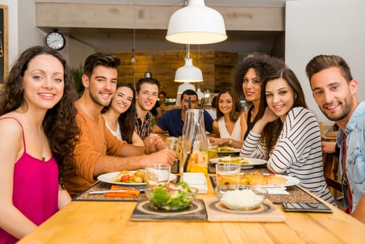 Multi-Ethnic Group of happy friends lunching and having fun at the restaurant