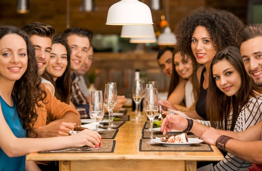 Multi-Ethnic Group of happy friends lunching and having fun at the restaurant