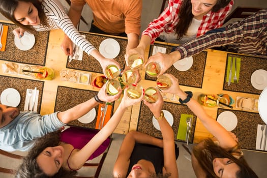Group of people toasting and looking happy at a restaurant