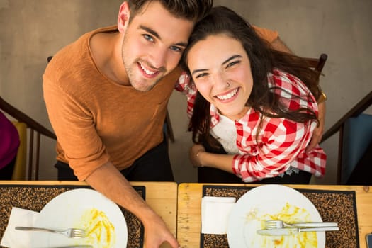 Young couple toasting and looking happy at a restaurant