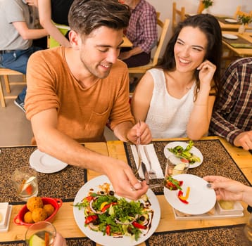 Young couple toasting and looking happy at a restaurant