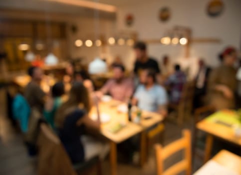 Blurred image of friends lunching and having fun at the restaurant