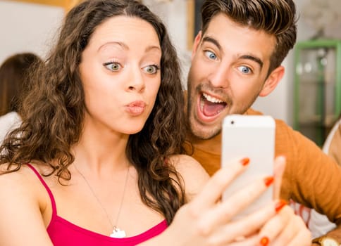 Happy couple at the restaurant making a selfie