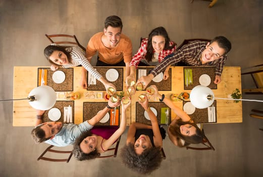 Group of people toasting and looking happy at a restaurant