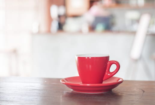 Red coffee cup on wooden table, stock photo