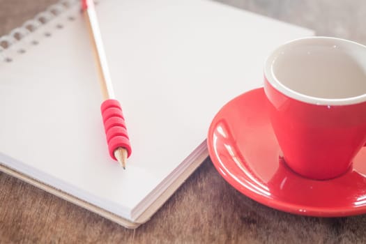 Red mug with open notebook, stock photo