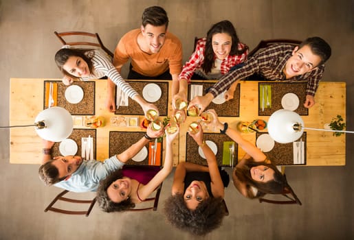 Group of people toasting and looking happy at a restaurant