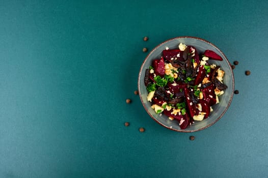 Diet salad of boiled beets, nuts and goat cheese on the plate. Flat lay.