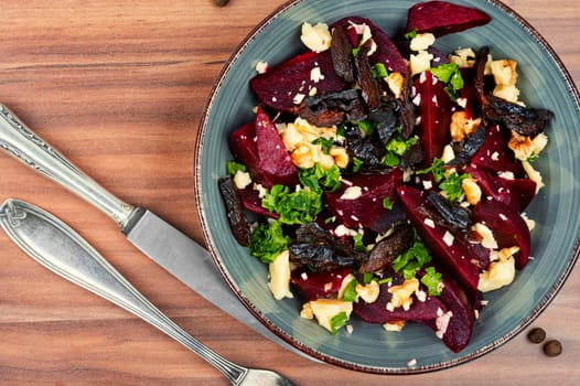 Diet salad of boiled beets, nuts and goat cheese on the plate. Flat lay.