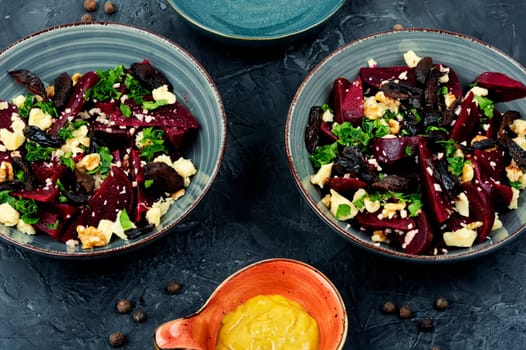 Diet salad of boiled beets, nuts and goat cheese on the plate. Flat lay.