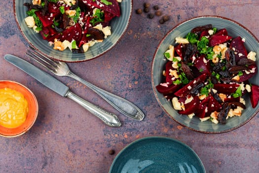 Diet salad of boiled beets, nuts and goat cheese on the plate. Flat lay.