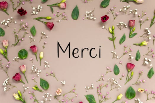 Flower Arrangement With Merci Means Thank You. Colorful Spring Blossoms And Flowers Like Roses Building A Frame. Flat Lay With Brown Paper Background