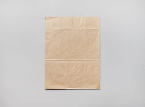 Blank kraft paper pack on gray paper background. Responsive design mockup. Flat lay.