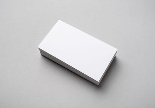Stack of blank business cards on gray paper background. Branding mock up.