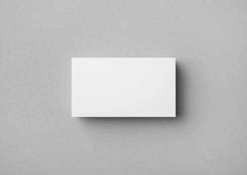 Blank business card on gray paper background. Mock-up for branding identity. Flat lay.