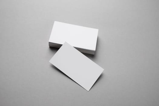 Photo of blank business cards on gray paper background. Template for your design.