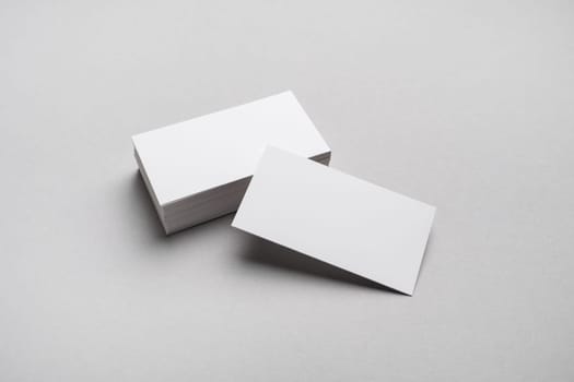 Blank white business cards on gray paper background. Mockup for ID.