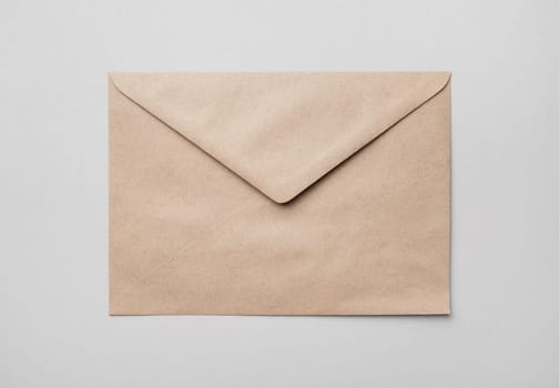 Blank kraft paper envelope on gray paper background. Flat lay.