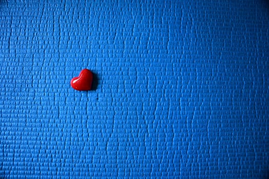 red heart lying on a blue ground