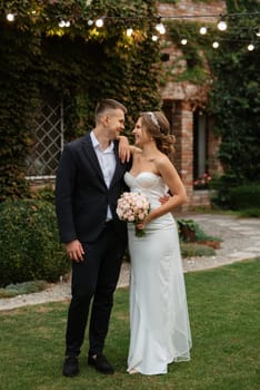 portrait of a young couple of bride and groom on their wedding day in a country cottage