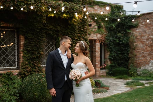 portrait of a young couple of bride and groom on their wedding day in a country cottage