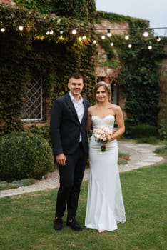 portrait of a young couple of bride and groom on their wedding day in a country cottage