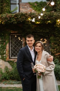 portrait of a young couple of bride and groom on their wedding day in a country cottage