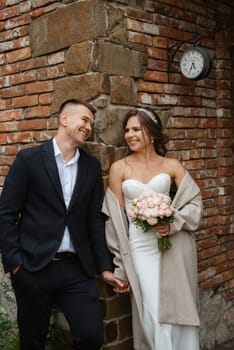 portrait of a young couple of bride and groom on their wedding day in a country cottage