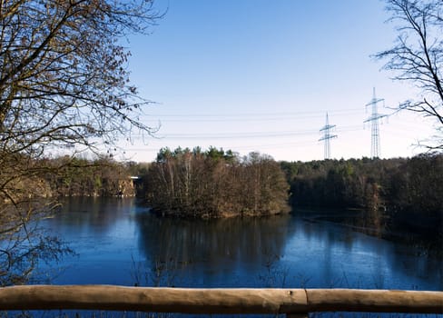 little green isle in a stone pits lake, local recreation area, power poles in the back