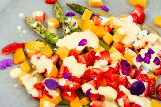 Light spring salad of berries, green asparagus, mango and yogurt. Copy space. Banner.