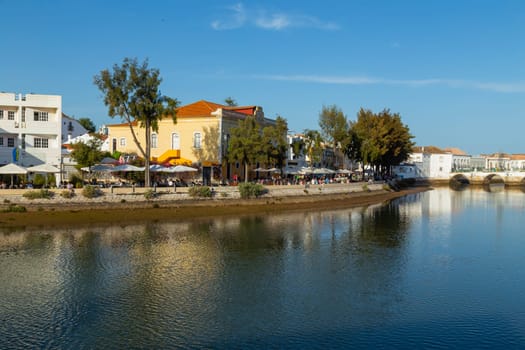 AVIRA, PORTUGAL - April 17, 2022 - Waterfront townhouses along the riverbank of the Gilao river with steps leading to the water, Tavira, Algarve, Portugal
