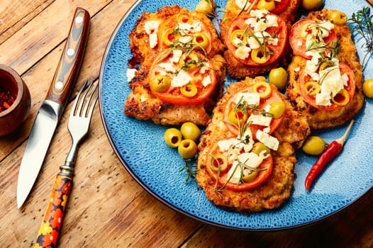 Chicken schnitzel with piece tomato, olives and cheese. Healthy keto. Top view