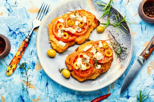 Chicken schnitzel with piece tomato, olives and cheese. Healthy keto. Top view