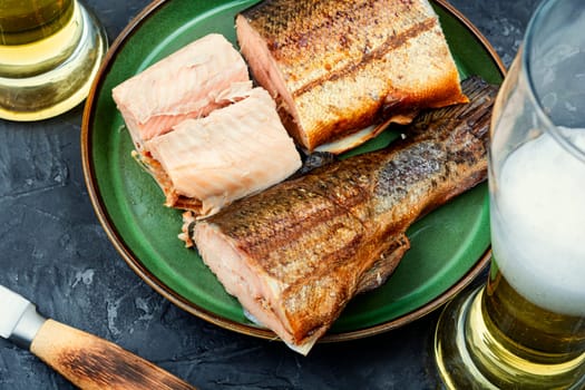 Tasty hot smoked trout salmon with beer