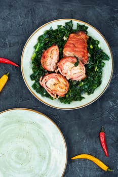 Sliced Baked chicken meat breast roll with fried spinach garnish.