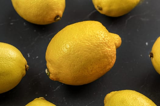 Top view - whole lemons on black marble board.