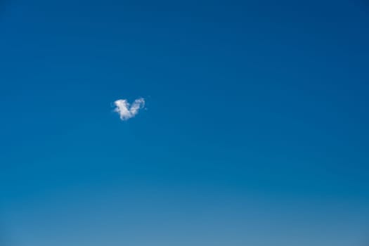 heart shaped cloud in the blue sky.