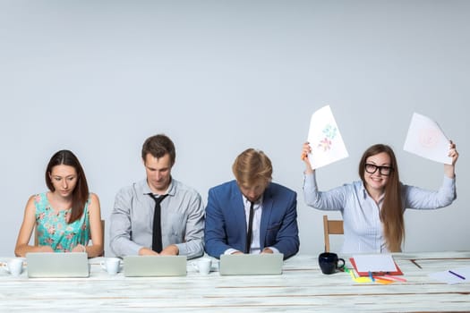 Business team working together at office on light gray background. all working on laptops. boss enjoying a good idea. copyspace image
