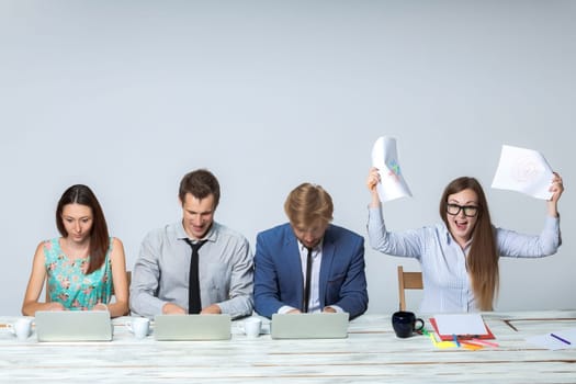 Business team working together at office on light gray background. all working on laptops. boss enjoying a good idea. copyspace image