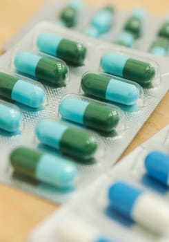 Medicine in capsule on wood table, Selective focus