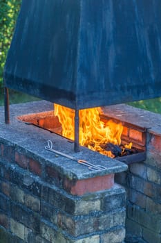 Open fire in the garden grill with rust and smoke extractor made of steel
