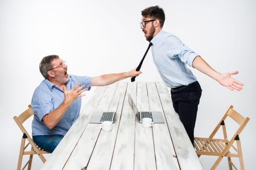 Business conflict. The two men expressing negativity while one man grabbing the necktie of her opponent on white background