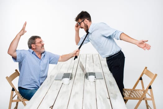 Business conflict. The two men expressing negativity while one man grabbing the necktie of her opponent on white background
