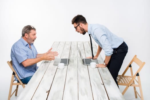 The two colleagues working together at office on light gray background. Both are looking at the computer screens and  surprising.  the concept of competition in the business