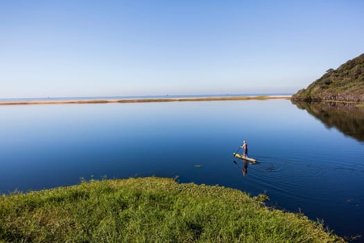 Blue lagoon rural river water paddler board  coastline scenic landscape