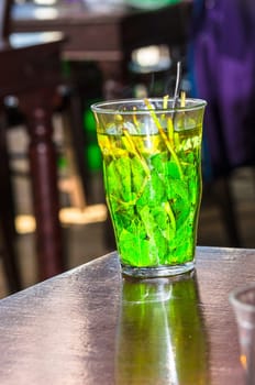 Glass filled with beautiful fresh green peppermint tea leaves.