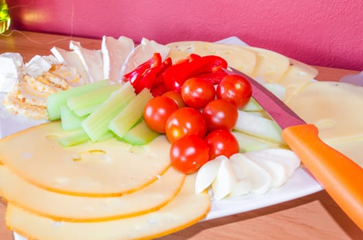 Cheese platter garnished with fruit and vegetables/cheese platter.