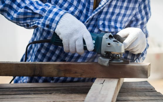 carpenter using grinder on wood