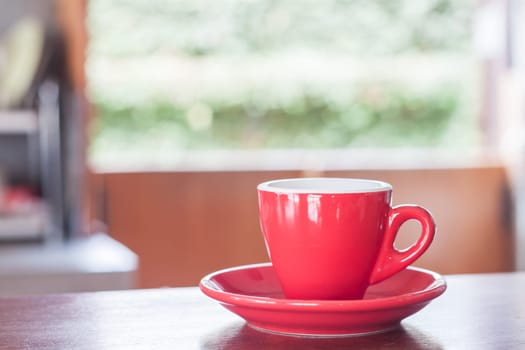 Red coffee cup on wooden table, stock photo